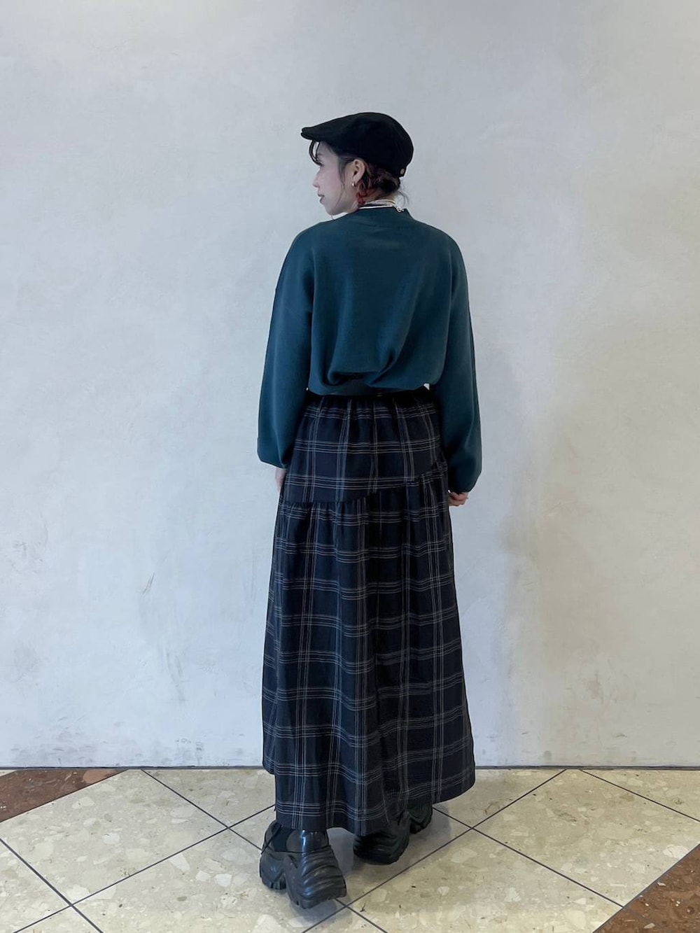 ブラック系のブーツ、グリーン系のニット/セーター、ブラック系のスカートを着用したレディースの秋コーディネートの3枚目の写真