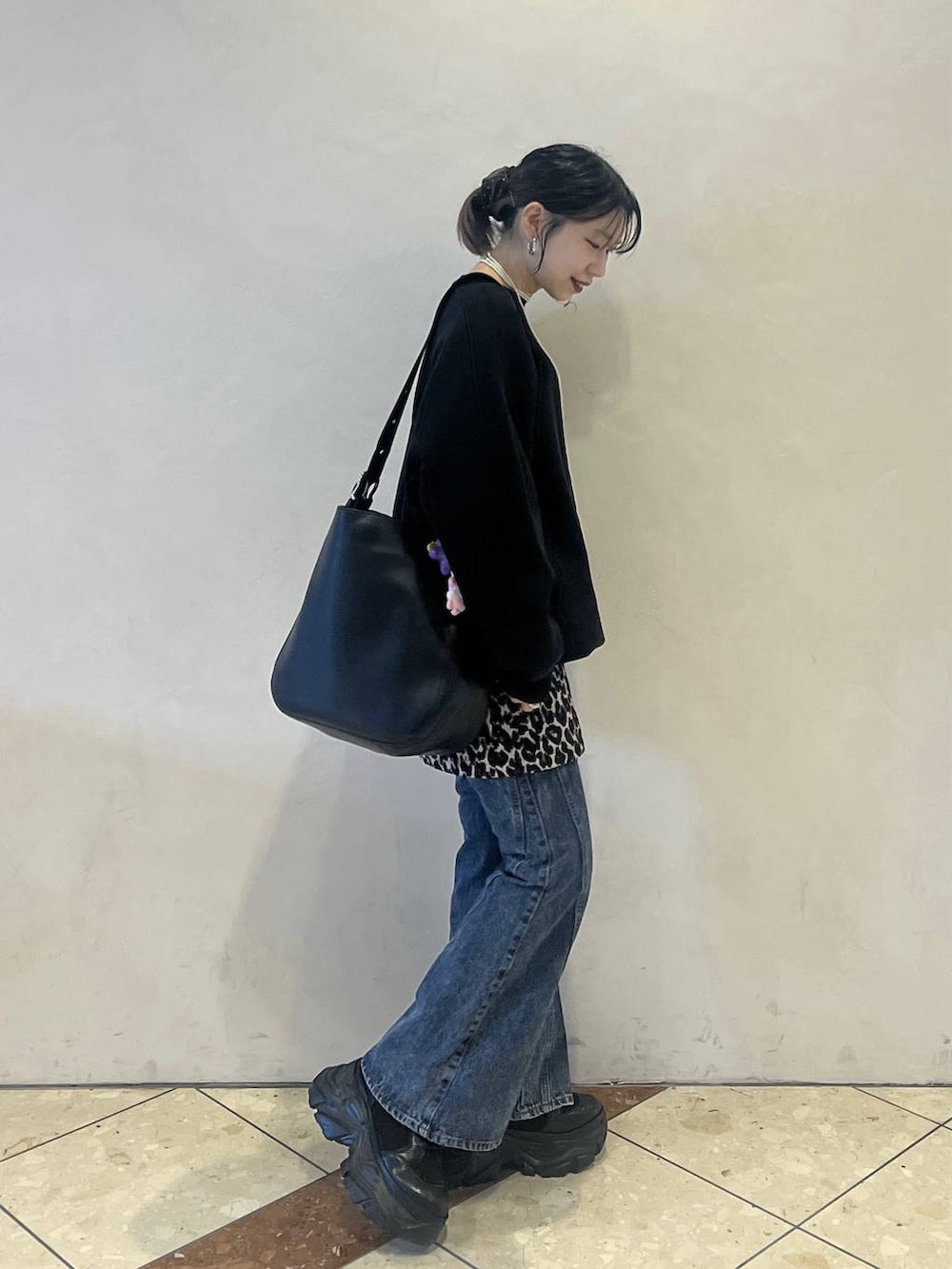 ブラック系のブーツ、ブラック系のニット/セーター、ブラック系のショルダーバッグを着用したレディースの冬コーディネートの2枚目の写真