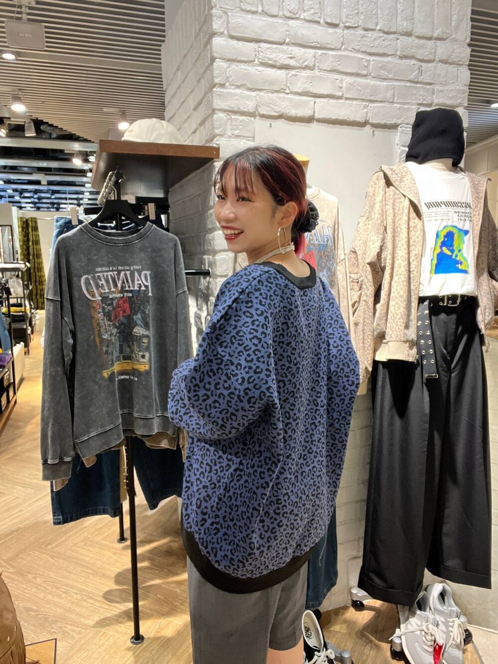 グレー系のスラックス、ブルー系のカーディガン/ボレロを着用したレディースの秋コーディネートの2枚目の写真