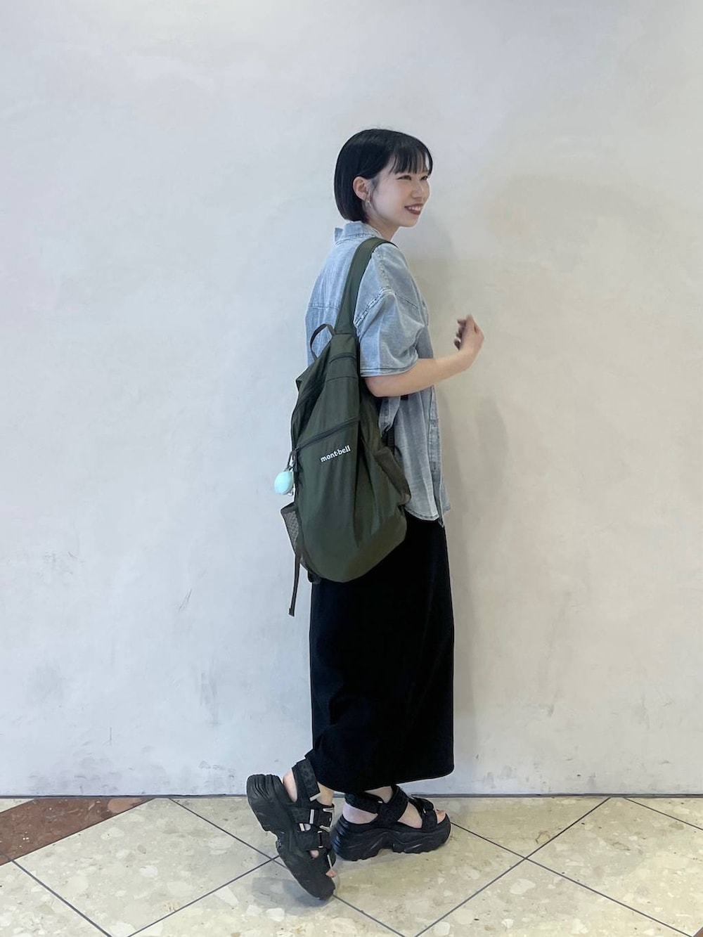 ブルー系のシャツ/ブラウス、ブラック系のワンピース、ブラック系のサンダルを着用したレディースの春コーディネートの2枚目の写真