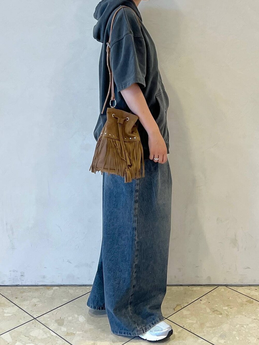 ブルー系のデニムパンツ、グレー系のパーカー、ブラック系のデジタル腕時計を着用したレディースの夏コーディネートの2枚目の写真