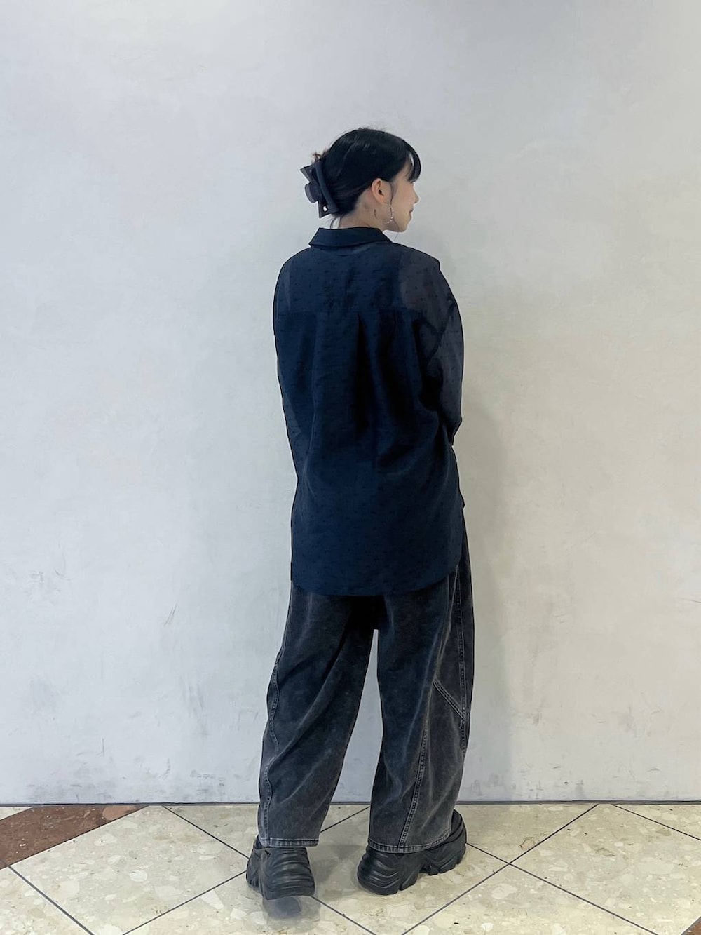 ブラック系のスニーカー、ブラック系のデニムパンツ、ブラック系のショルダーバッグを着用したレディースの夏コーディネートの3枚目の写真