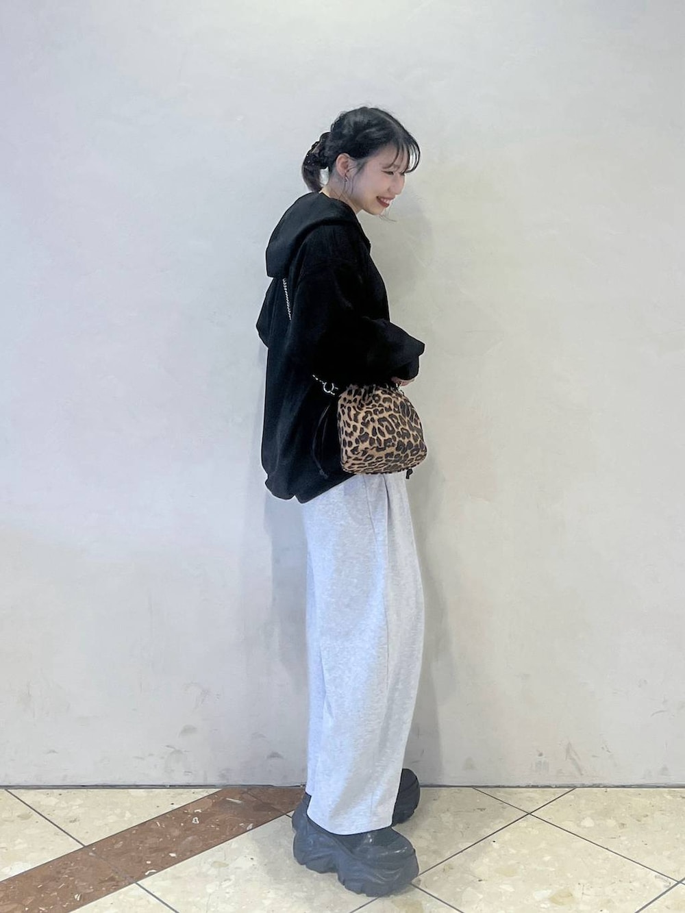 ブラック系のブーツ、グレー系のスウェットパンツ、ブラック系のパーカーを着用したレディースの冬コーディネートの2枚目の写真