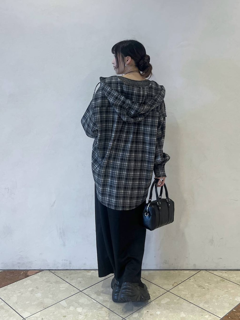 ブラック系のブーツ、ブラック系のスカート、ブラック系のボストンバッグを着用したレディースの冬コーディネートの3枚目の写真