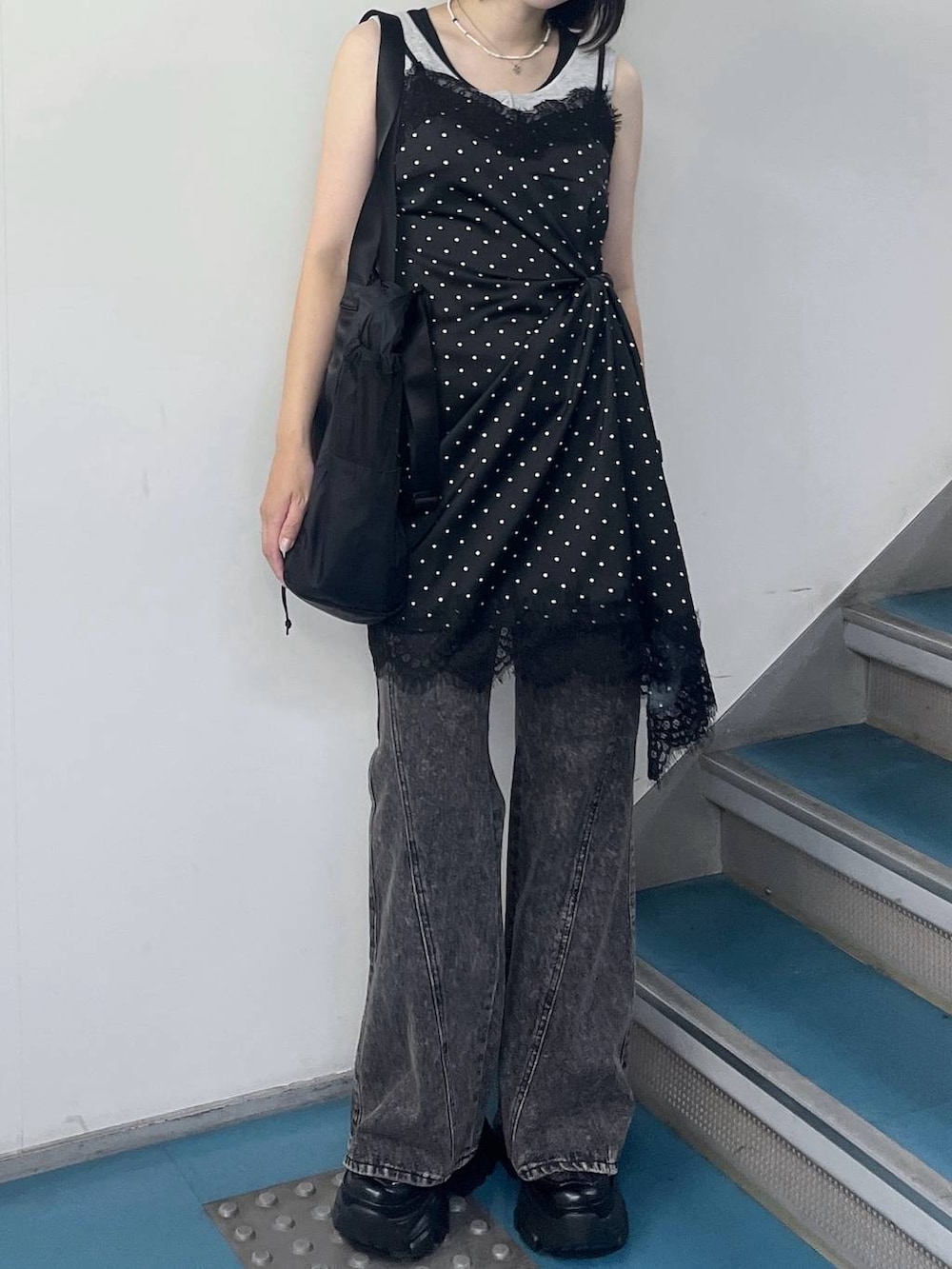 ブラック系のチュニック、ブラック系のスニーカー、ブラック系のデニムパンツを着用したレディースの夏コーディネートの2枚目の写真