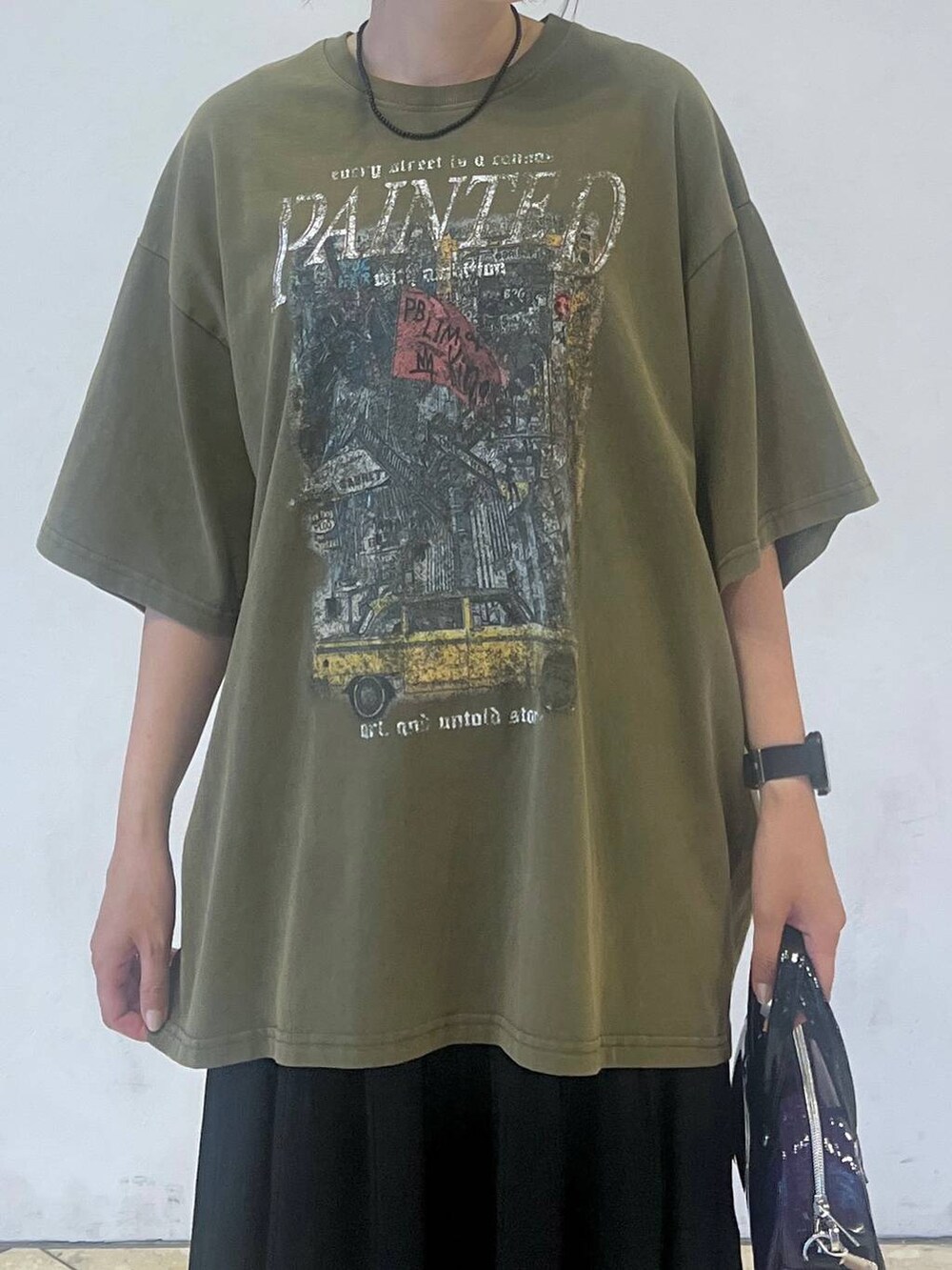 グリーン系のTシャツ/カットソー、ブラック系のスカートを着用したレディースの夏コーディネートの3枚目の写真