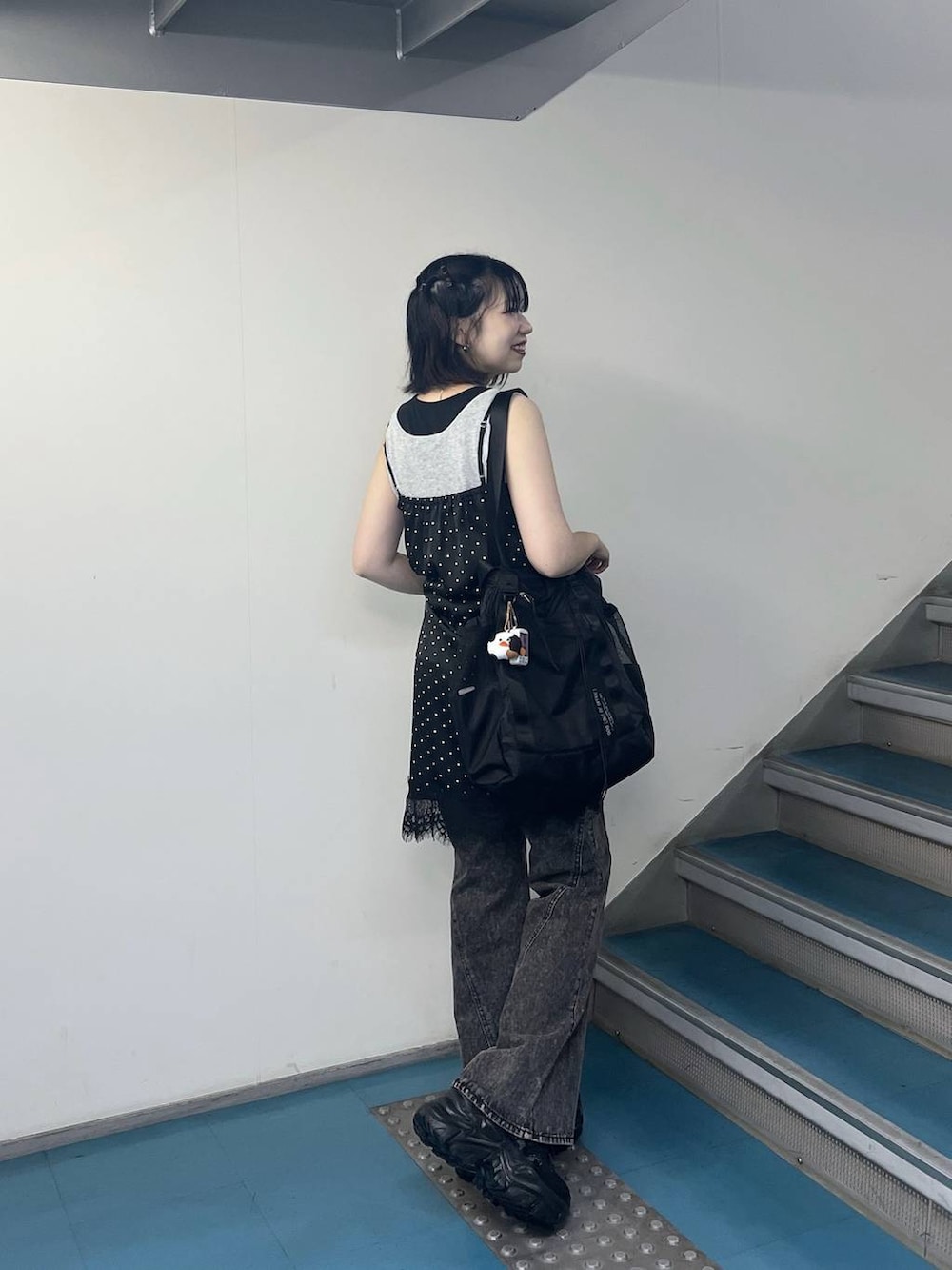 ブラック系のチュニック、ブラック系のスニーカー、ブラック系のデニムパンツを着用したレディースの夏コーディネートの4枚目の写真