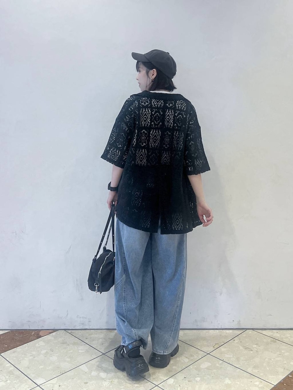 ブルー系のデニムパンツ、ブラック系のサンダル、ブラック系のトートバッグを着用したレディースの夏コーディネートの3枚目の写真
