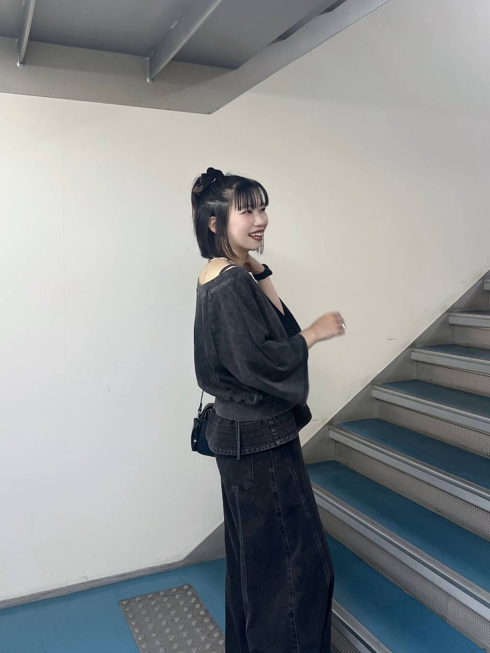 ブラック系のデニムパンツ、ブラック系のTシャツ/カットソー、ブラック系のショルダーバッグを着用したレディースの夏コーディネートの3枚目の写真