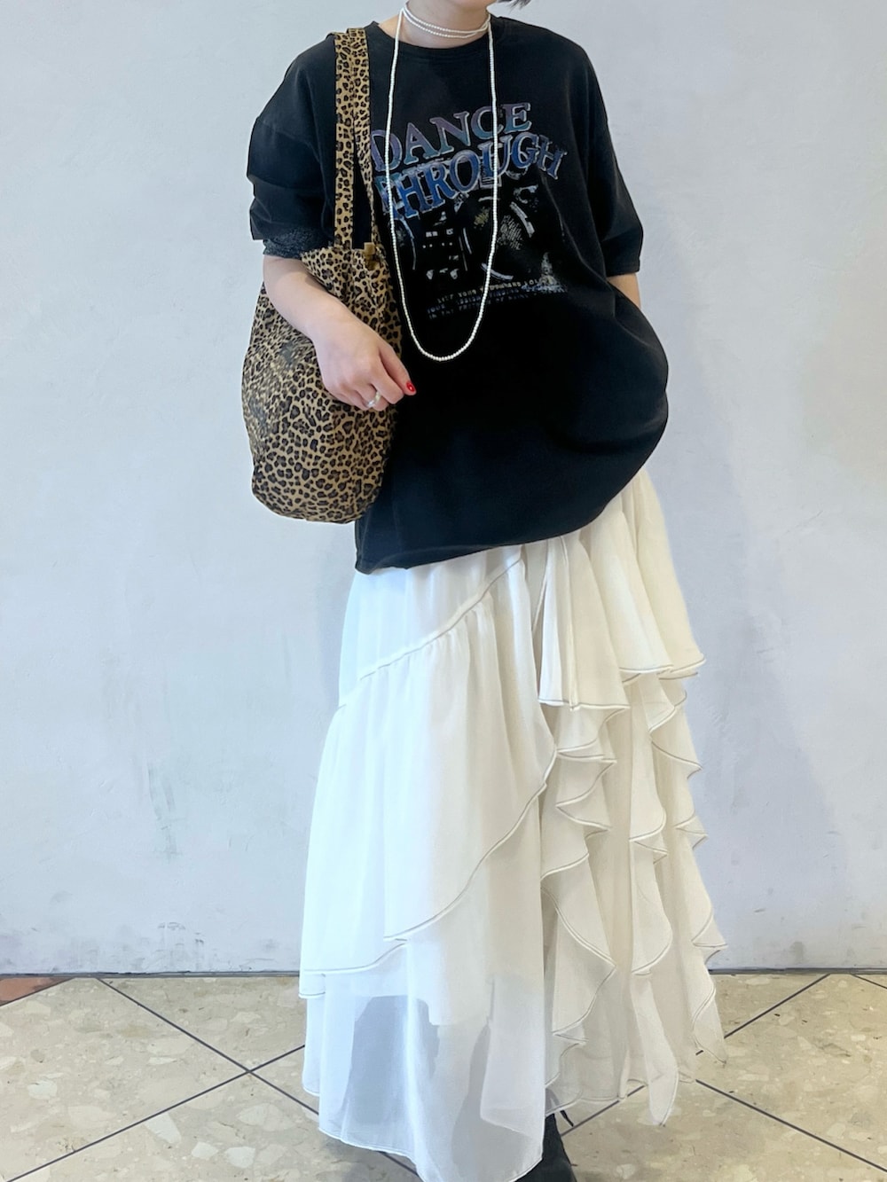 ホワイト系のスカート、ブラック系のスニーカー、グレー系のTシャツ/カットソーを着用したレディースの春コーディネートの3枚目の写真