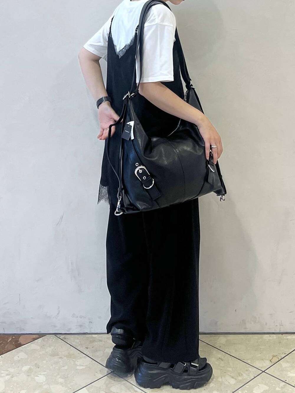 ブラック系のショルダーバッグ、ブラック系のチュニック、ホワイト系のTシャツ/カットソーを着用したレディースの夏コーディネートの2枚目の写真
