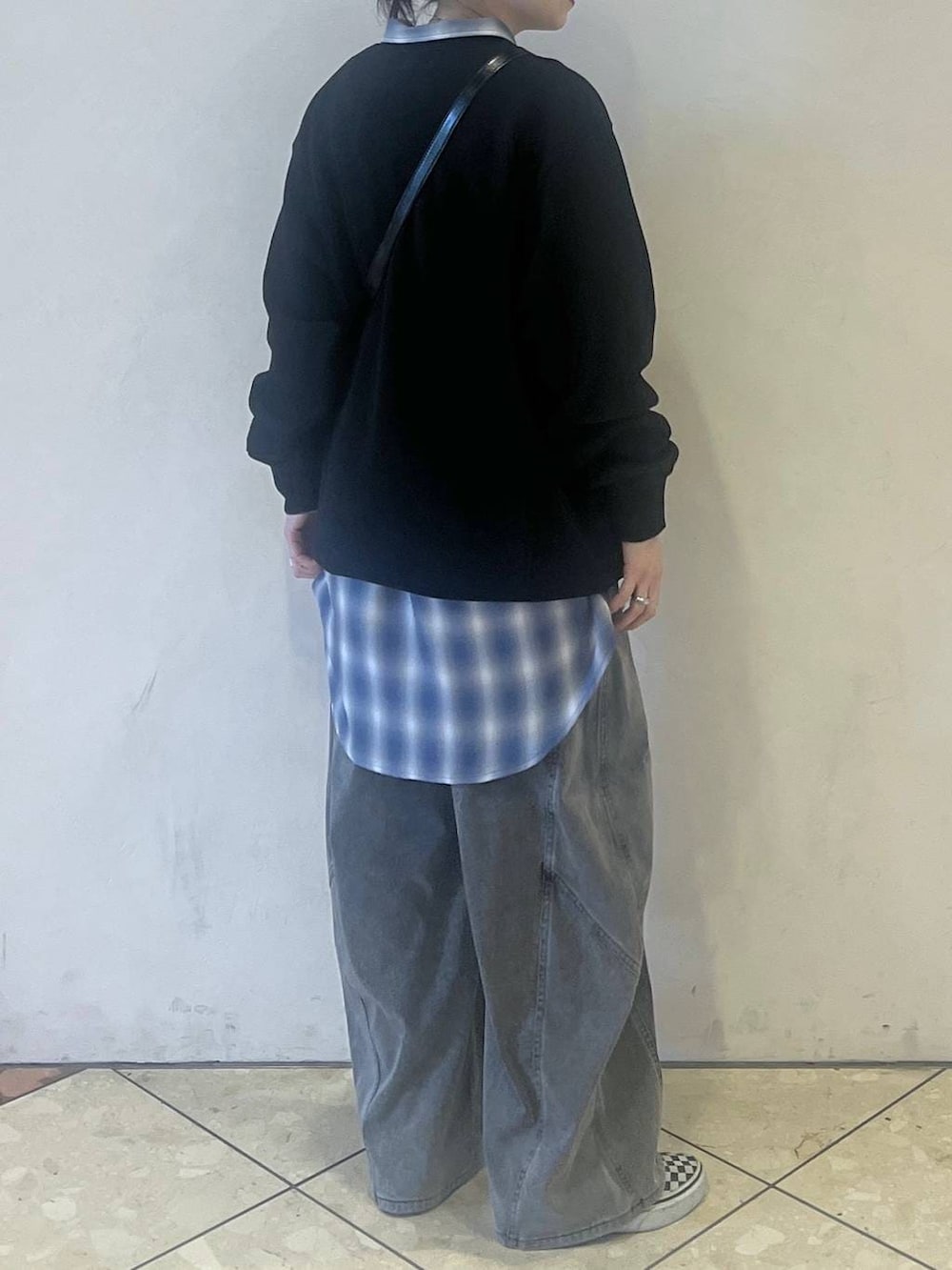 ブラック系のスウェット、ブラック系のデニムパンツ、ブラック系のショルダーバッグを着用したレディースの春コーディネートの2枚目の写真