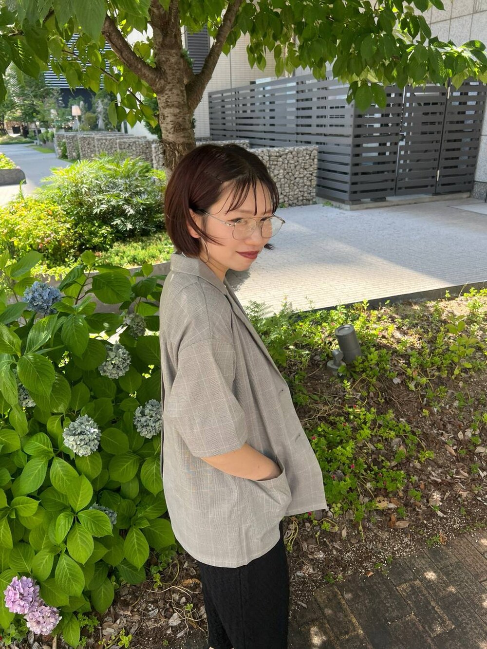 ブラック系のタンクトップ、ブラウン系のショルダーバッグ、ベージュ系のテーラードジャケットを着用したレディースの夏コーディネートの3枚目の写真