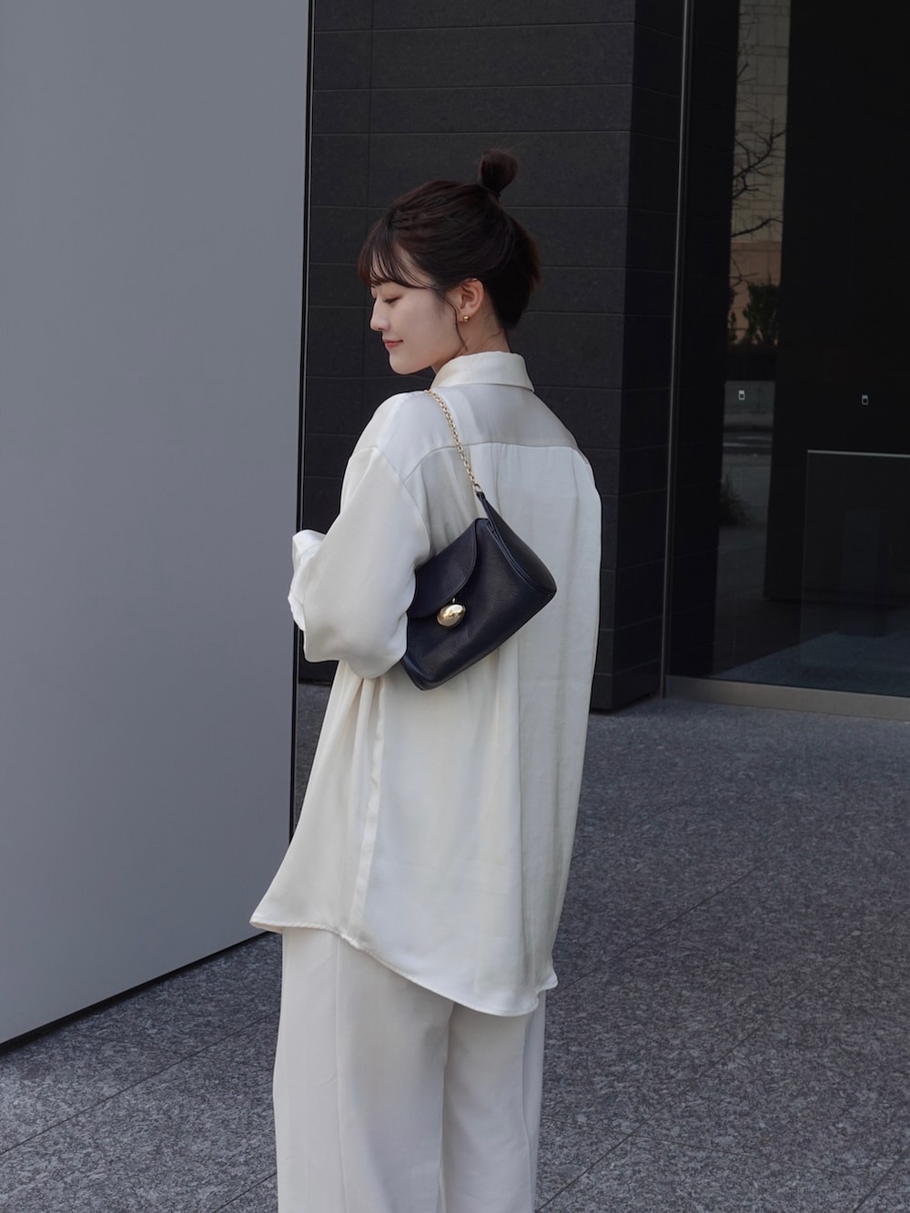 ホワイト系のシャツ/ブラウス、ホワイト系のスラックスを着用したレディースの冬コーディネートの2枚目の写真