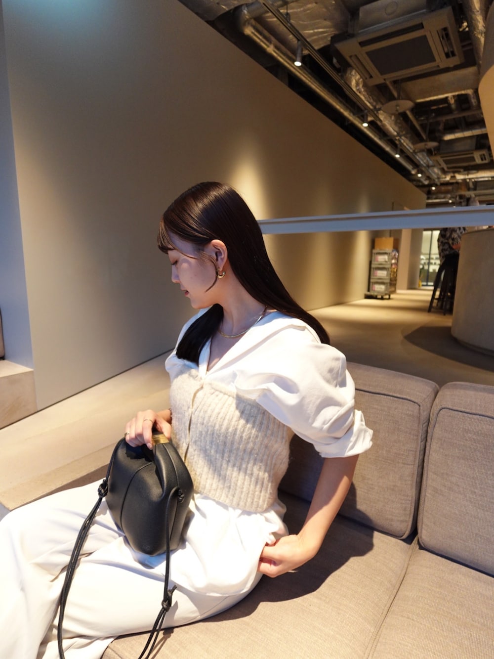 ブラック系のパンプス、ホワイト系のスラックス、ホワイト系のシャツ/ブラウスを着用したレディースの秋コーディネートの3枚目の写真