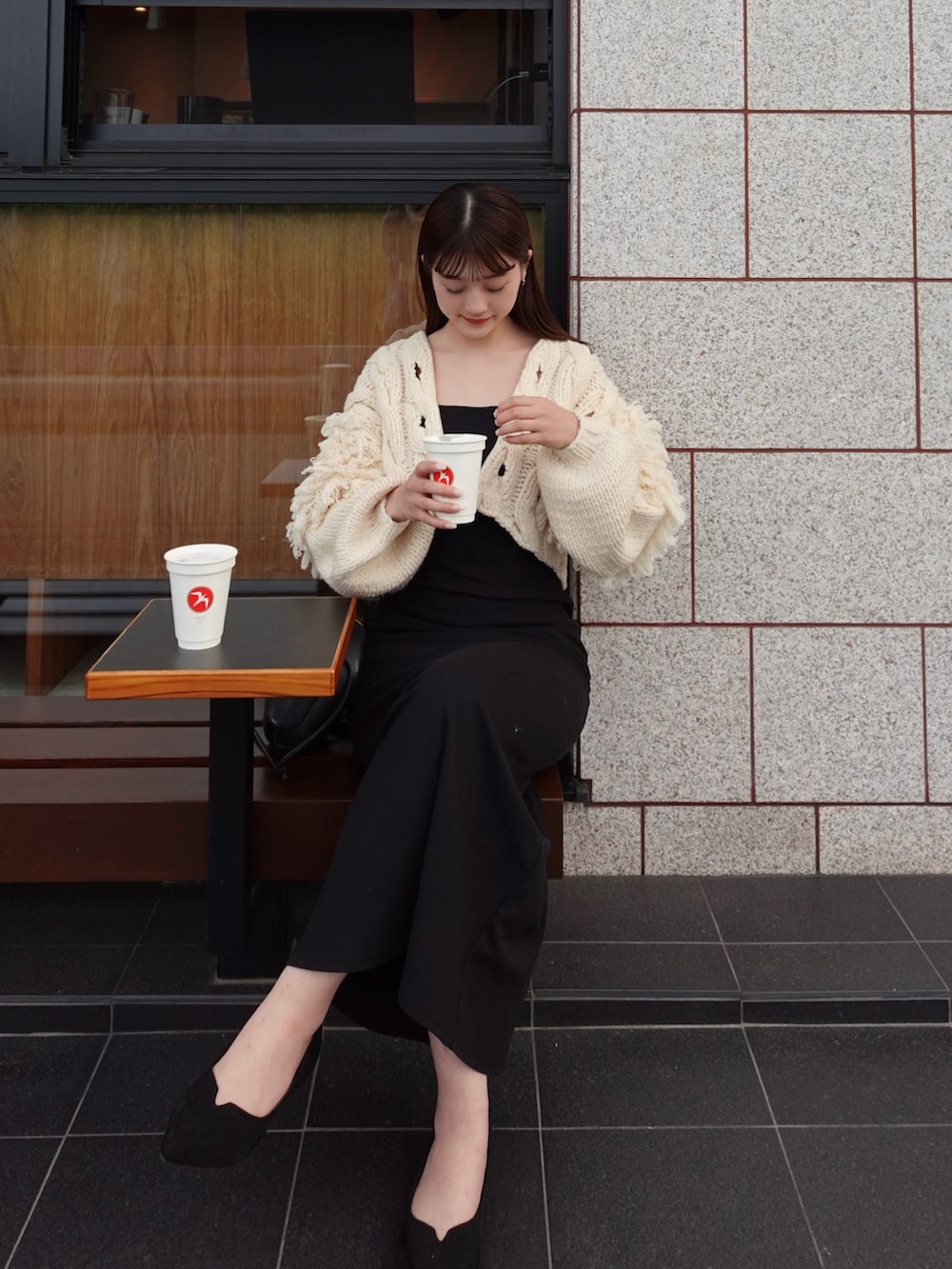 ブラック系のワンピース、ブラック系のパンプス、ホワイト系のトップスを着用したレディースの秋コーディネートの3枚目の写真