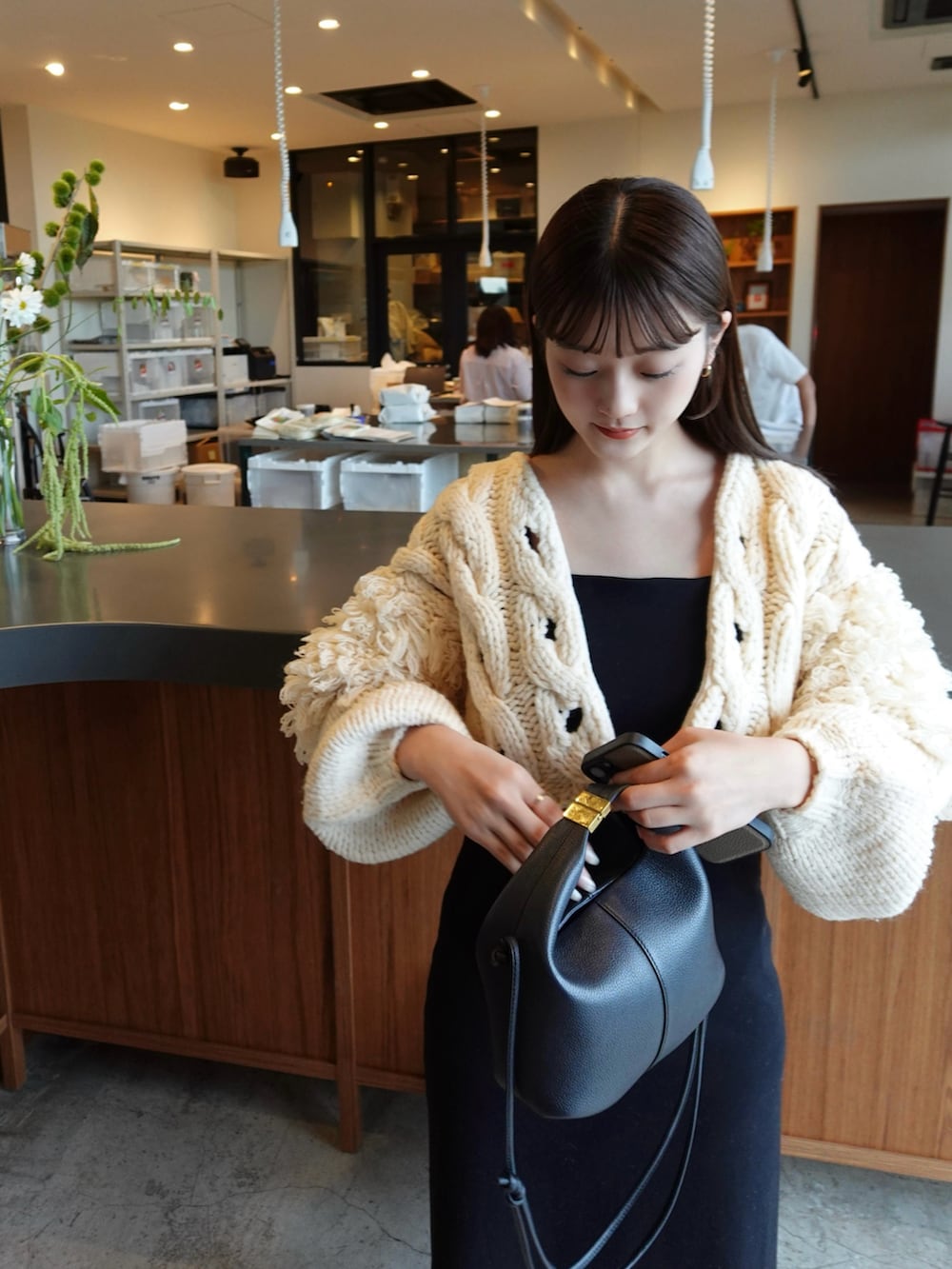 ブラック系のワンピース、ブラック系のパンプス、ホワイト系のトップスを着用したレディースの秋コーディネートの2枚目の写真