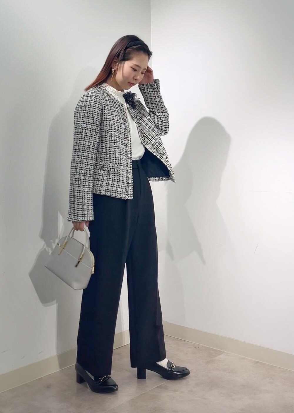 グレー系のショルダーバッグ、ホワイト系のシャツ/ブラウス、ブラック系のノーカラージャケットを着用したレディースの冬コーディネートの4枚目の写真