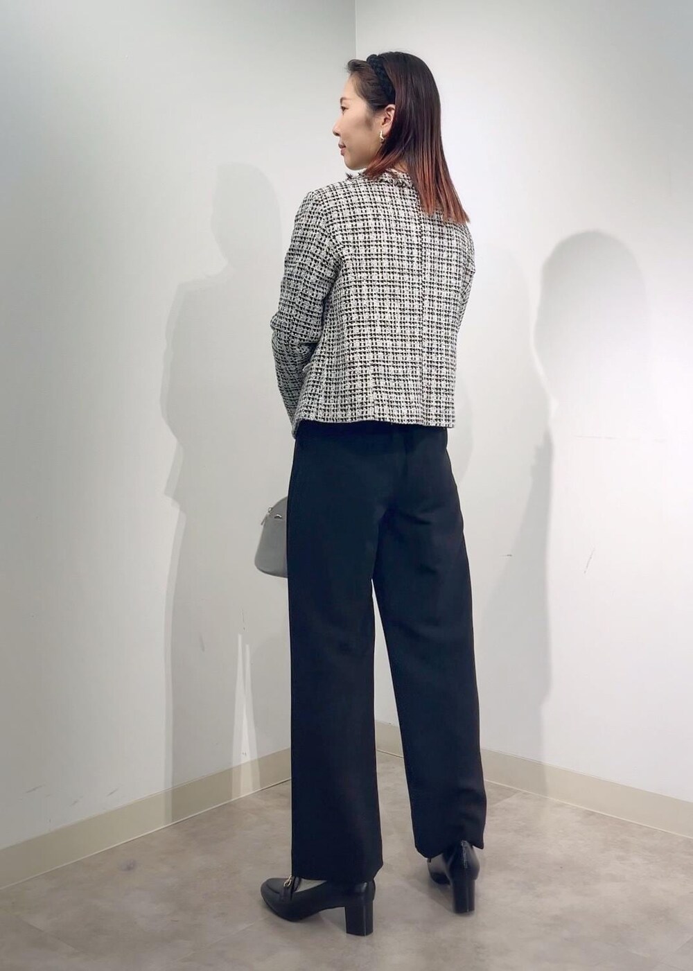 グレー系のショルダーバッグ、ホワイト系のシャツ/ブラウス、ブラック系のノーカラージャケットを着用したレディースの冬コーディネートの5枚目の写真