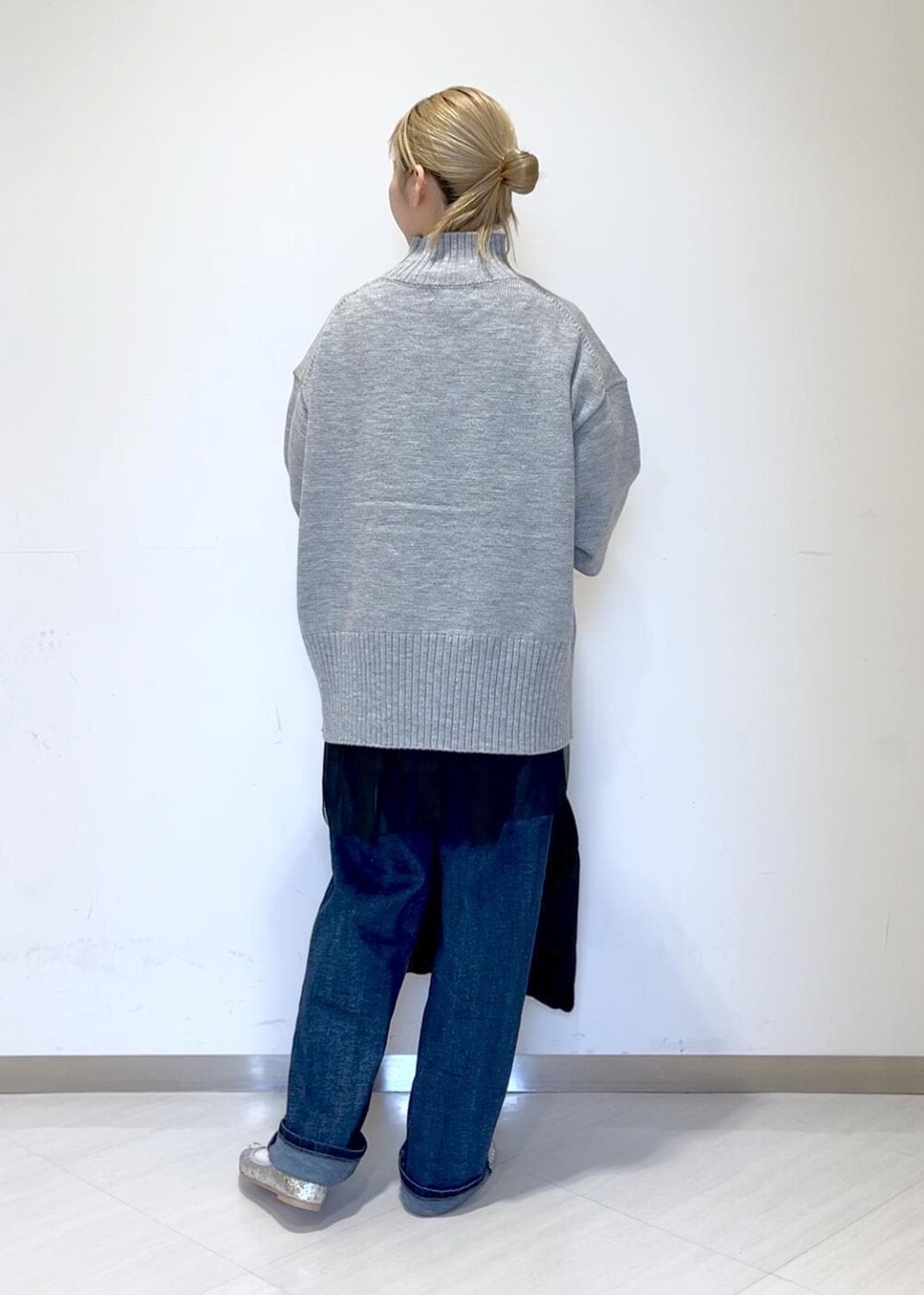 ブラック系のベスト、ブルー系のデニムパンツ、ブラック系のショルダーバッグを着用したレディースの秋コーディネートの4枚目の写真