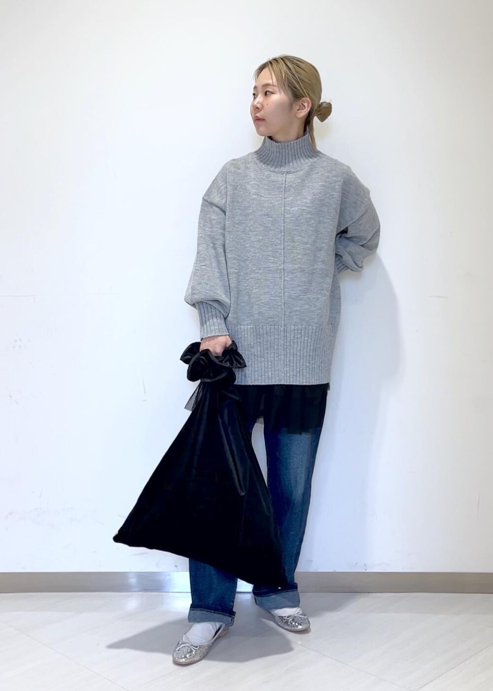 ブラック系のベスト、ブルー系のデニムパンツ、ブラック系のショルダーバッグを着用したレディースの秋コーディネートの3枚目の写真