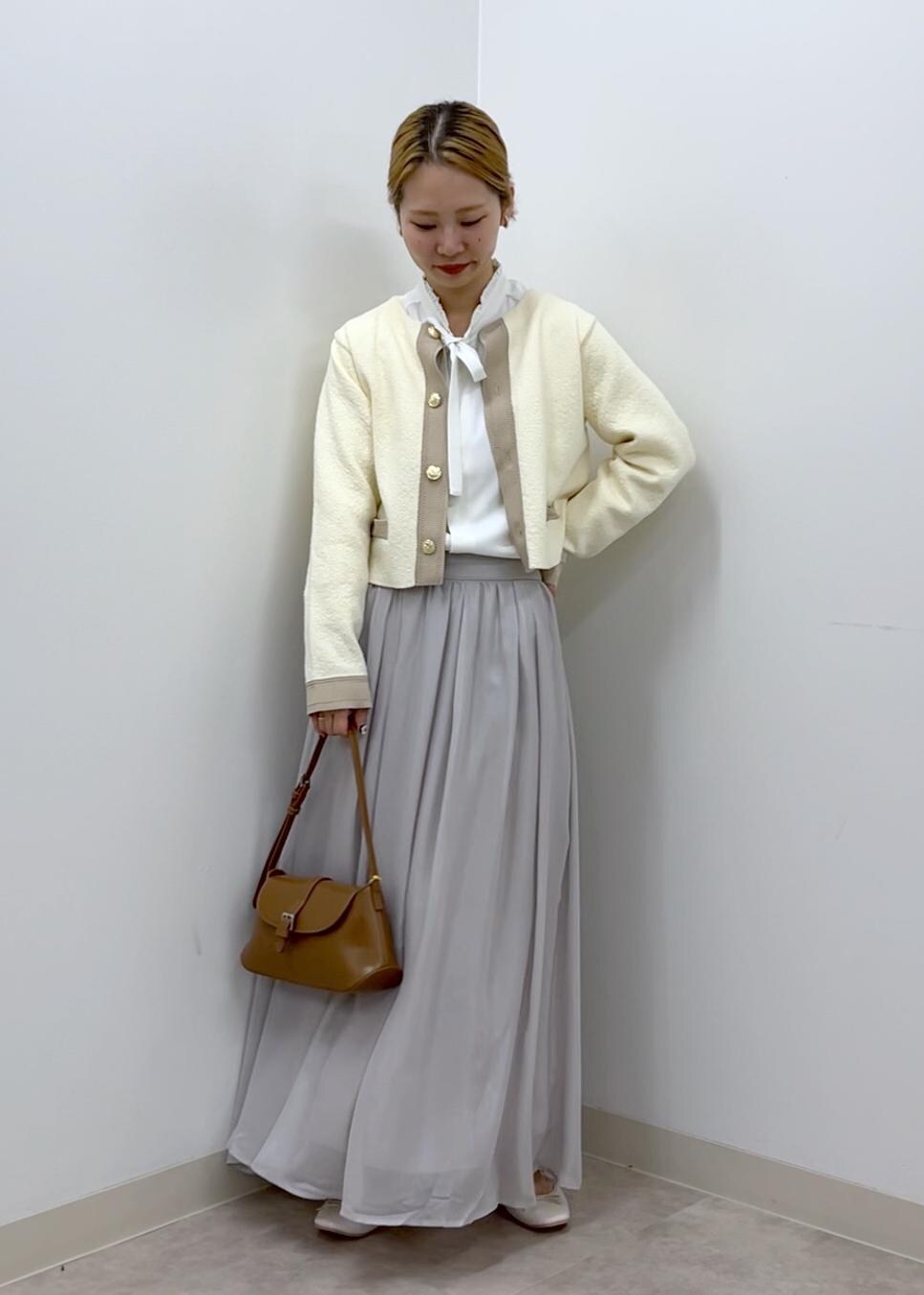 ホワイト系のカーディガン/ボレロ、ホワイト系のシャツ/ブラウス、ブラウン系のショルダーバッグを着用したレディースの秋コーディネートの2枚目の写真