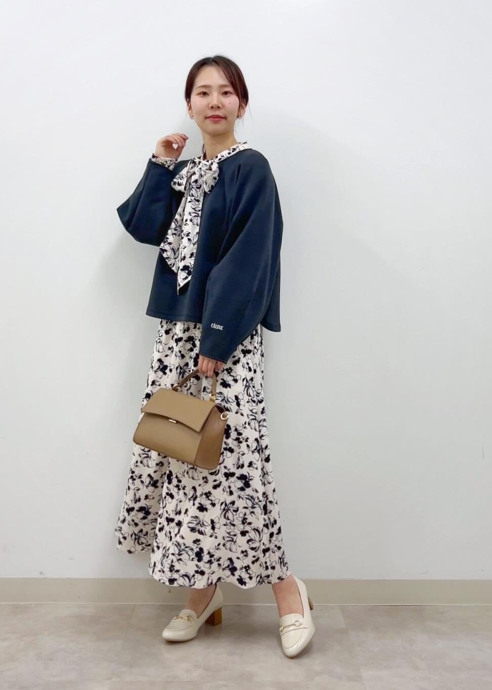 ブラウン系のショルダーバッグ、ホワイト系のワンピース、ホワイト系のローファーを着用したレディースの冬コーディネートの2枚目の写真