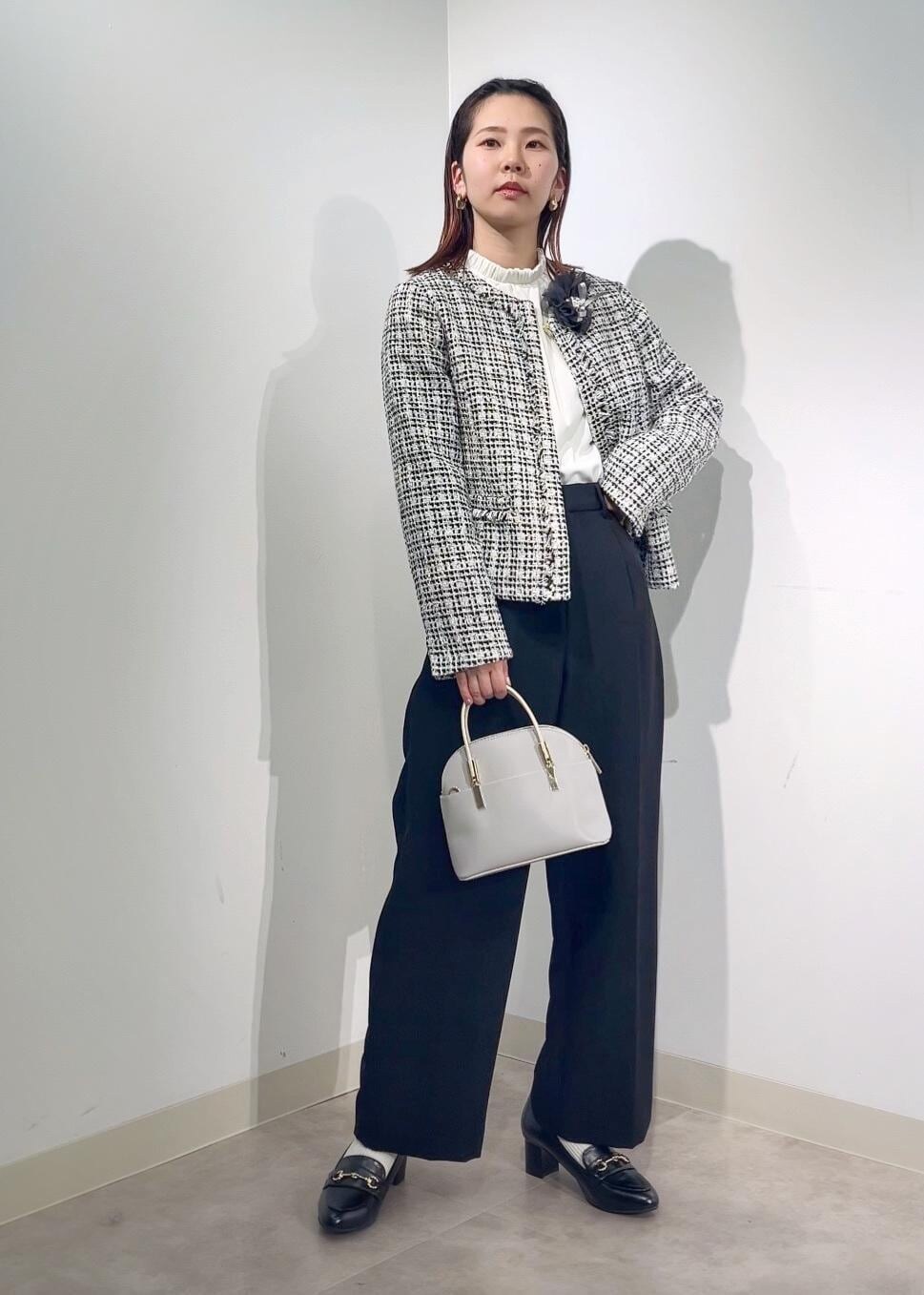 グレー系のショルダーバッグ、ホワイト系のシャツ/ブラウス、ブラック系のノーカラージャケットを着用したレディースの冬コーディネートの3枚目の写真