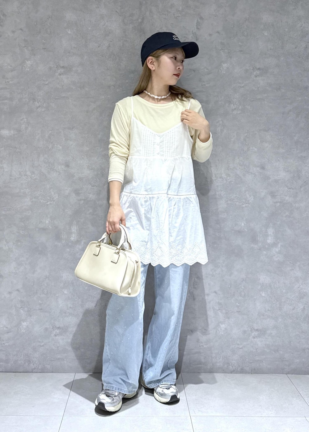 ブルー系のデニムパンツ、ホワイト系のボストンバッグ、ベージュ系のTシャツ/カットソーを着用したレディースの春コーディネートの8枚目の写真