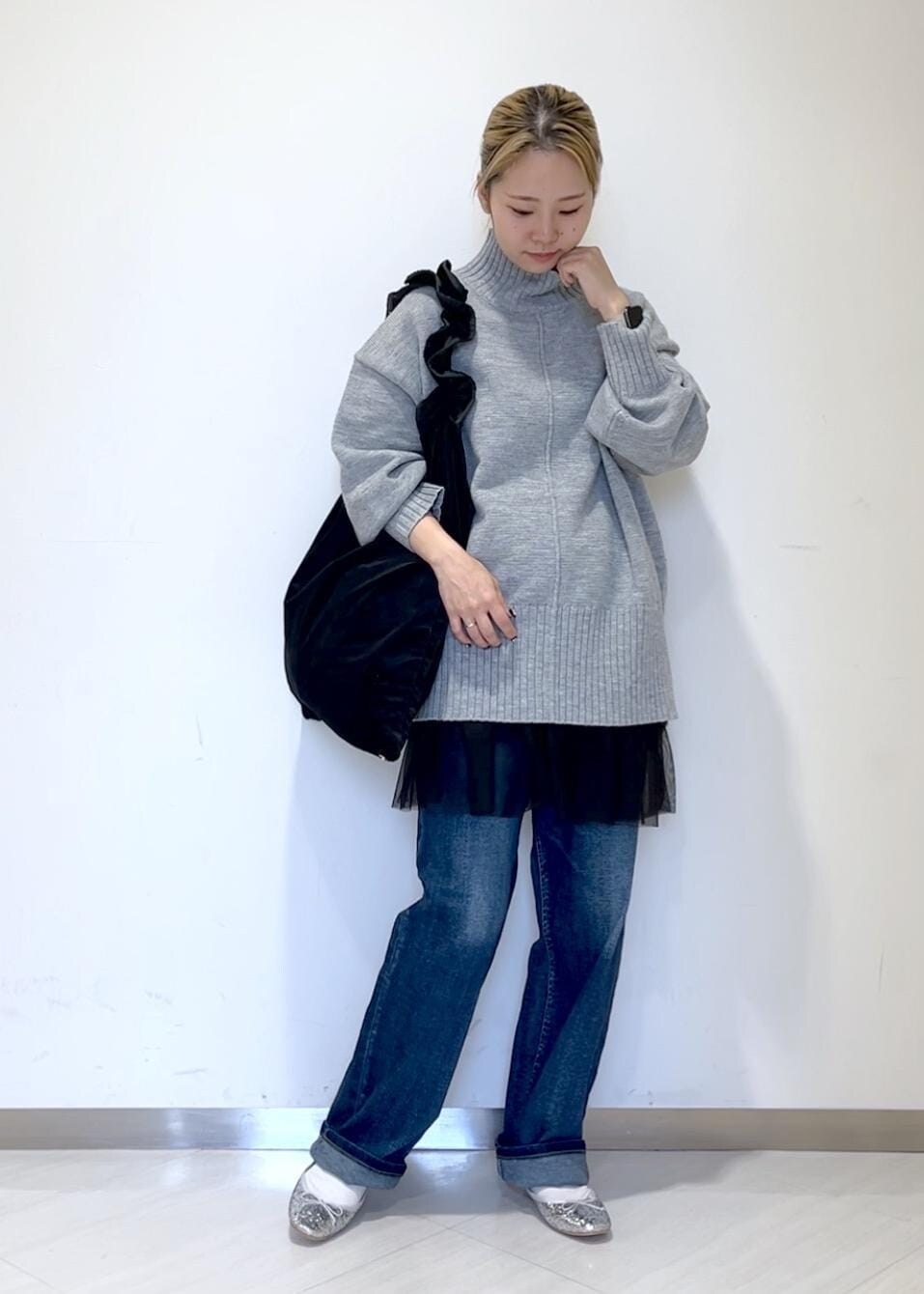 ブラック系のベスト、ブルー系のデニムパンツ、ブラック系のショルダーバッグを着用したレディースの秋コーディネートの2枚目の写真