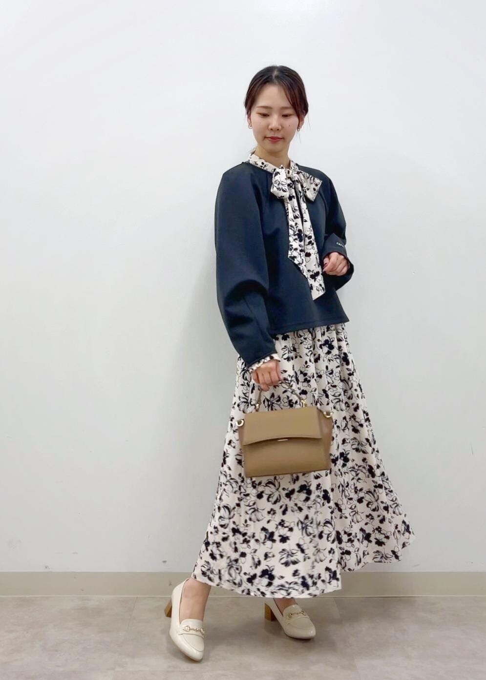 ブラウン系のショルダーバッグ、ホワイト系のワンピース、ホワイト系のローファーを着用したレディースの冬コーディネートの3枚目の写真