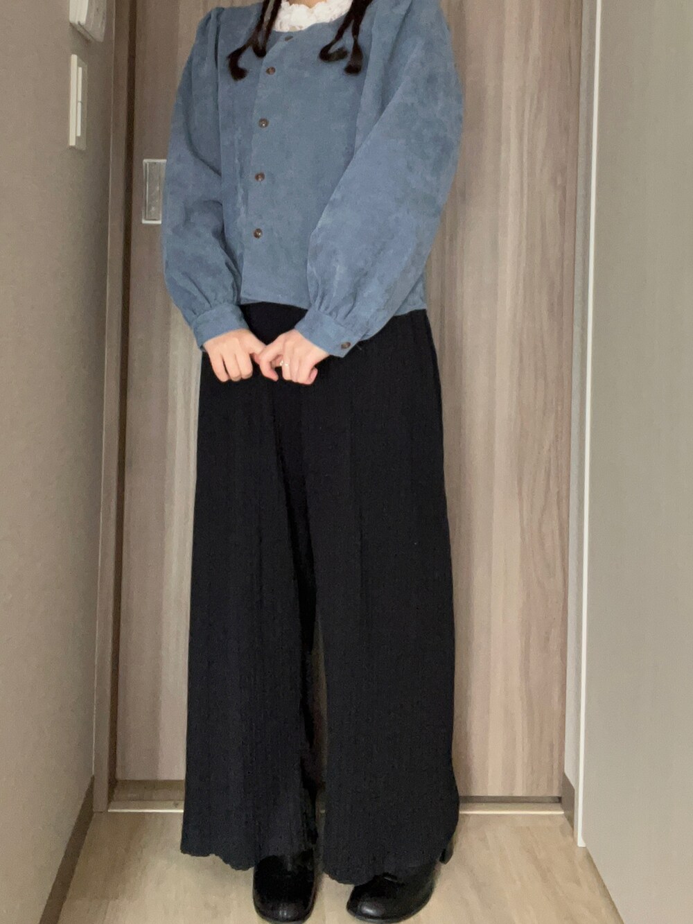 ブラック系のパンツ、ブラック系のブーツ、ブルー系のトップスを着用したレディースの冬コーディネートの2枚目の写真