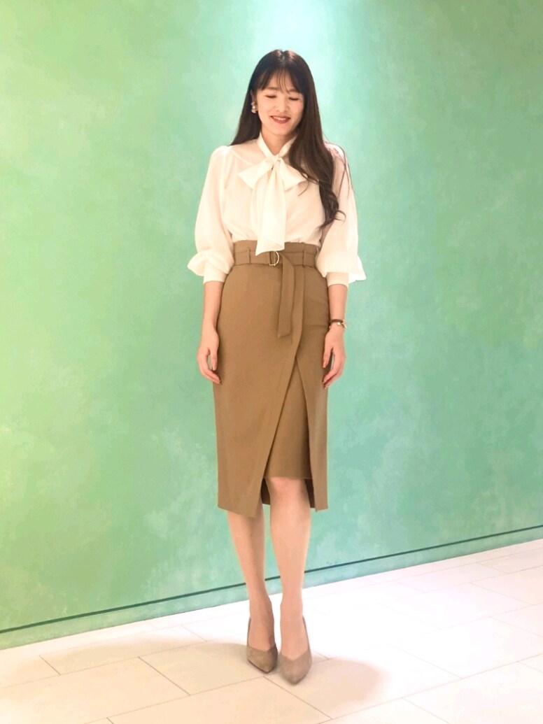 ホワイト系のシャツ/ブラウス、ホワイト系のテーラードジャケット、ブラウン系のスカートを着用したレディースの秋コーディネートの4枚目の写真