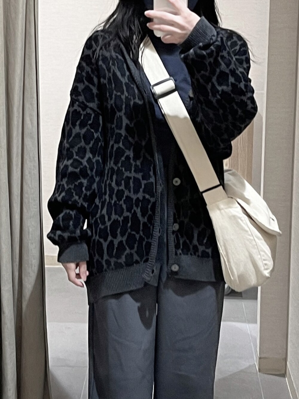 グレー系のスラックス、ブラック系のカーディガン/ボレロ、ブルー系のTシャツ/カットソーを着用したレディースの春コーディネートの2枚目の写真