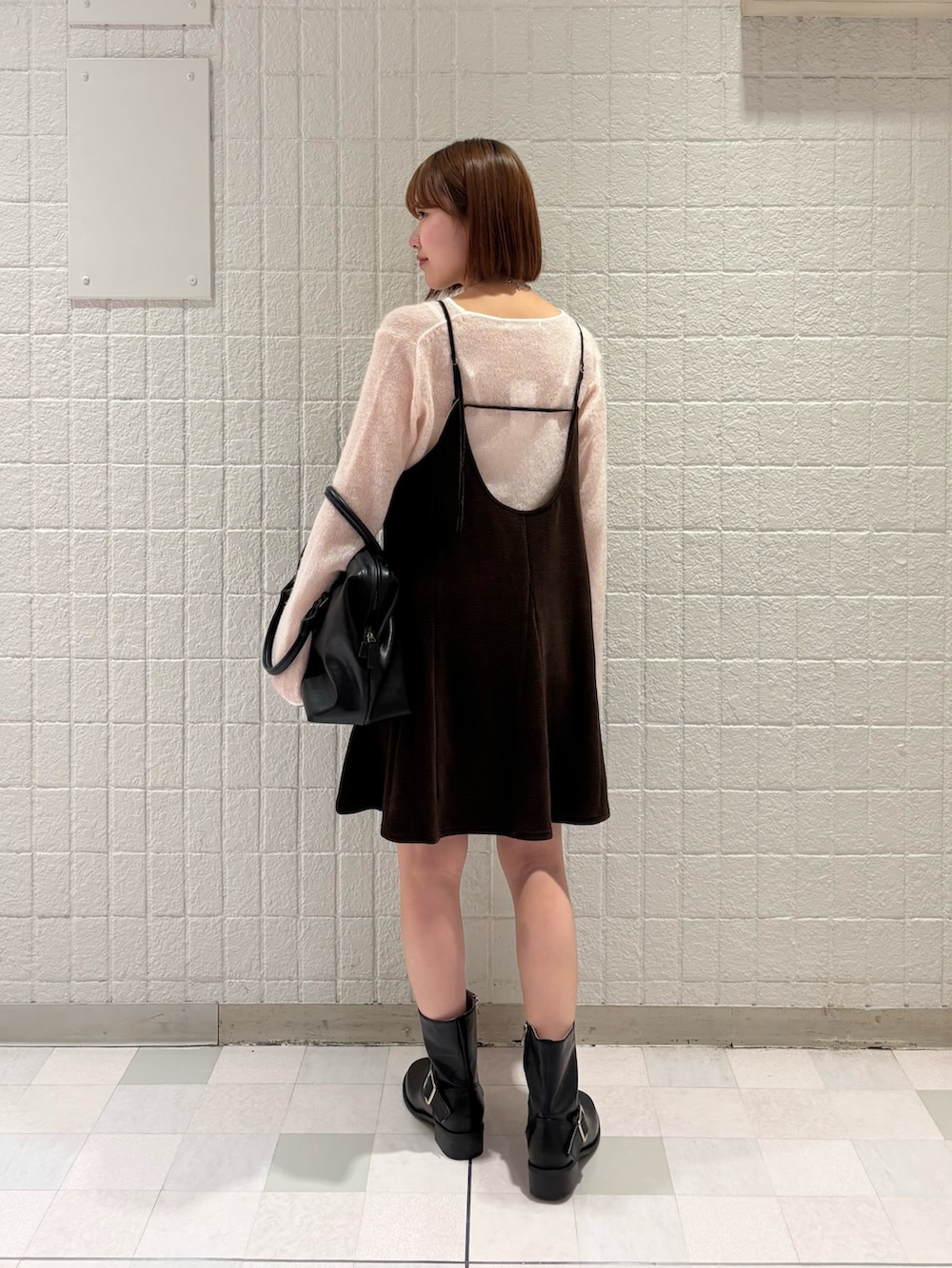 ピンク系のニット/セーター、ブラック系のボストンバッグ、ブラック系のブーツを着用したレディースの秋コーディネートの3枚目の写真