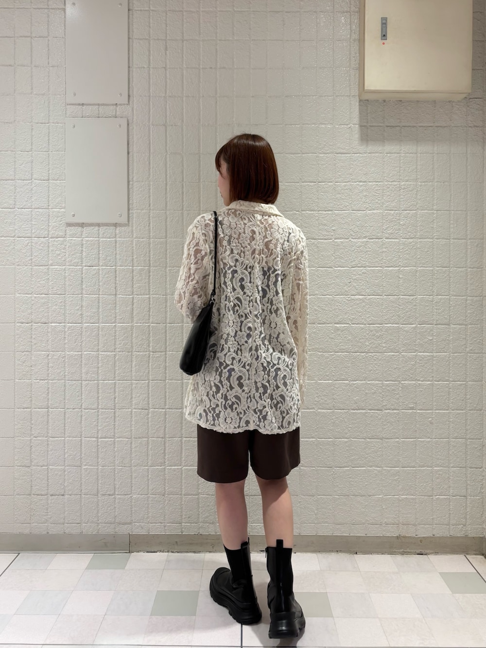 ブラック系のショルダーバッグ、ホワイト系のその他アウター、ブラウン系のその他パンツを着用したレディースの秋コーディネートの3枚目の写真