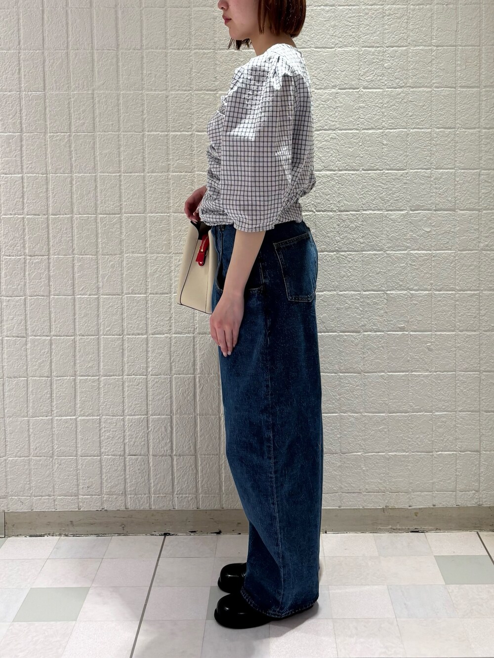 ホワイト系のシャツ/ブラウス、ブルー系のデニムパンツ、ホワイト系のハンドバッグを着用したレディースの春コーディネートの2枚目の写真