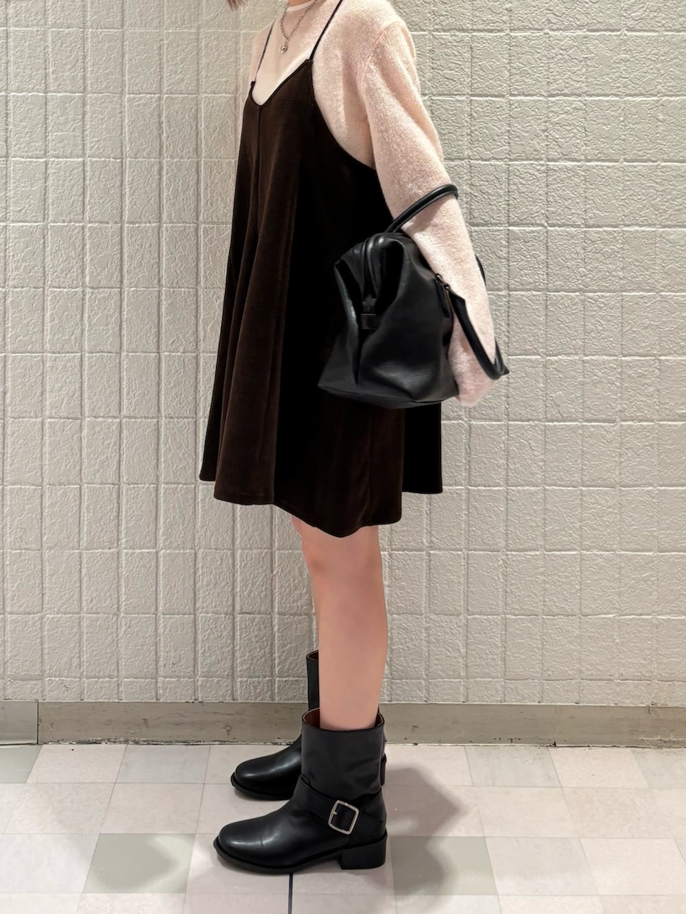 ピンク系のニット/セーター、ブラック系のボストンバッグ、ブラック系のブーツを着用したレディースの秋コーディネートの2枚目の写真