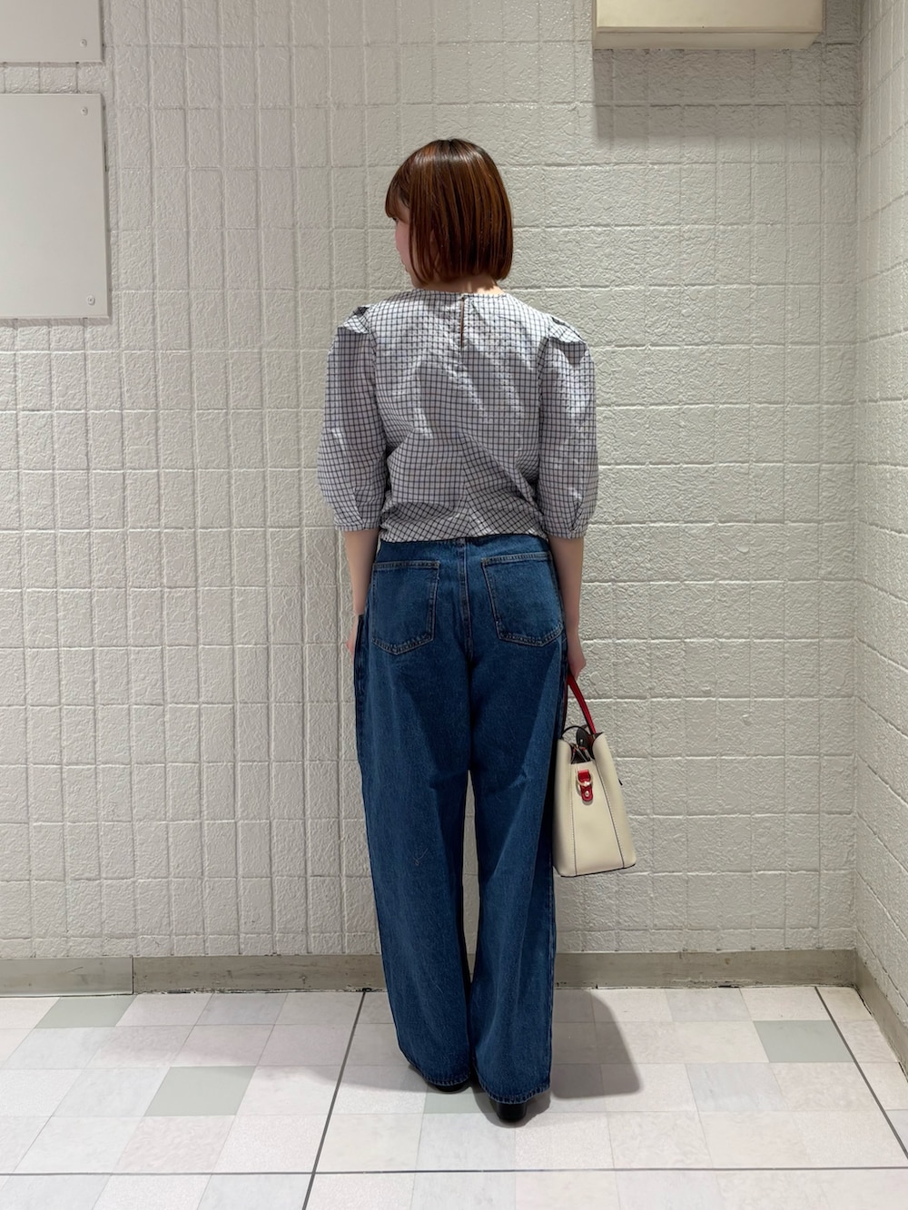 ホワイト系のシャツ/ブラウス、ブルー系のデニムパンツ、ホワイト系のハンドバッグを着用したレディースの春コーディネートの3枚目の写真