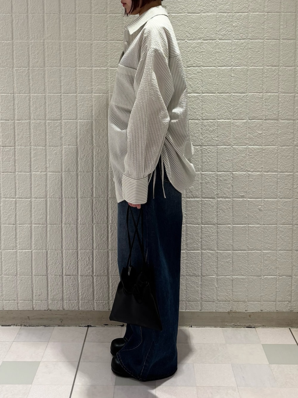 ブラック系のその他シューズ、ブラック系のショルダーバッグ、ブルー系のデニムパンツを着用したレディースの春コーディネートの2枚目の写真