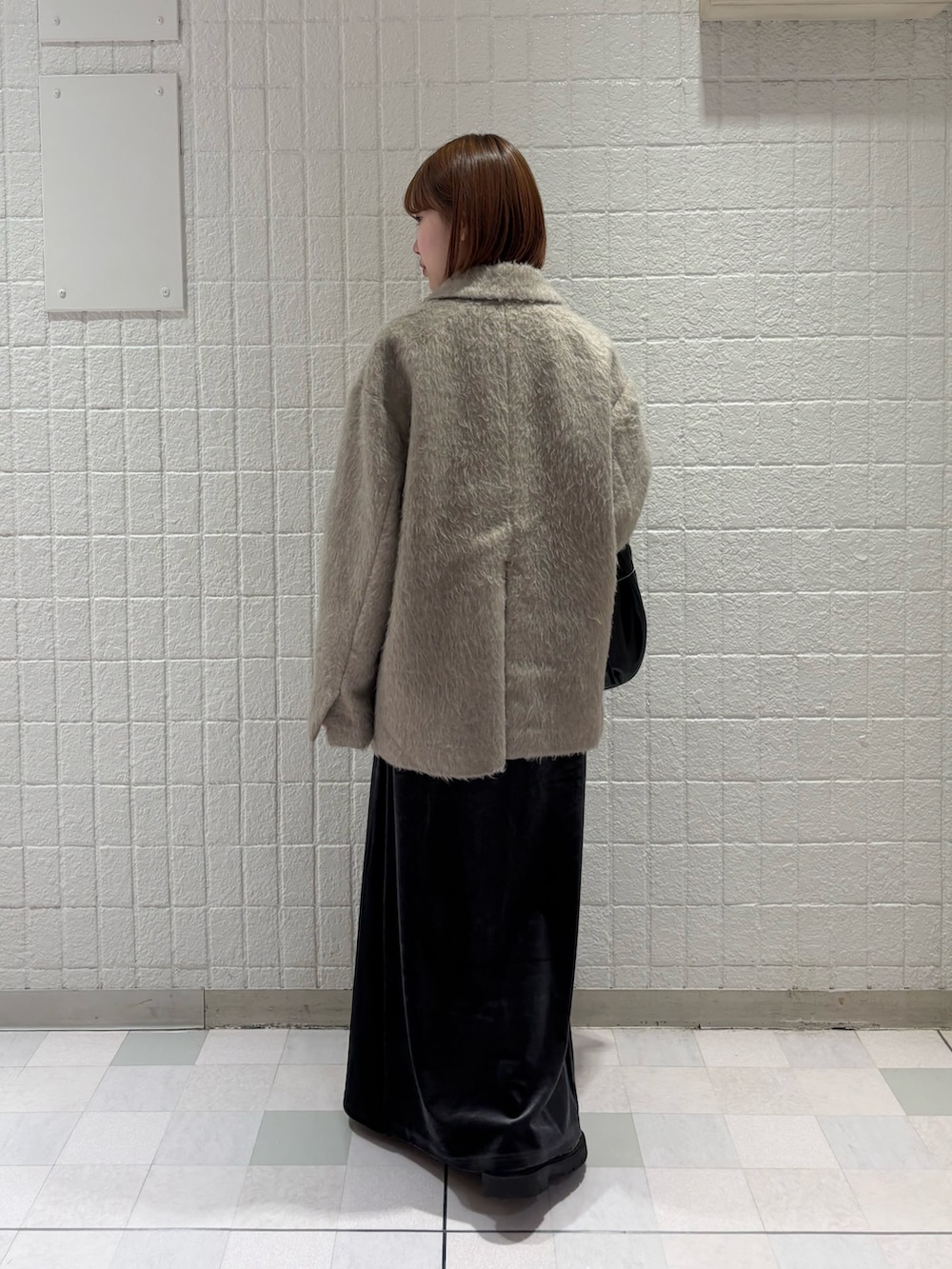 ブラウン系のその他アウター、ブラック系のハンドバッグ、グレー系のスカートを着用したレディースの秋コーディネートの3枚目の写真