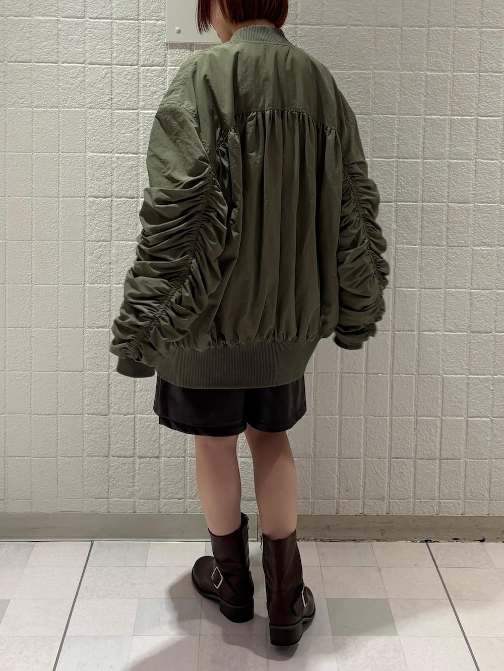 ブラウン系のその他パンツ、ブラウン系のブーツ、ホワイト系のTシャツ/カットソーを着用したレディースの秋コーディネートの4枚目の写真