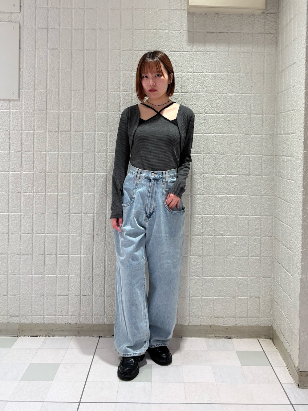 グレー系のキャミソール、ブルー系のデニムパンツを着用したレディースの春コーディネートの3枚目の写真