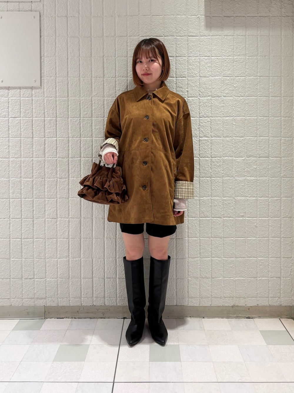 ホワイト系のニット/セーター、ブラック系のその他パンツ、ブラウン系のハンドバッグを着用したレディースの秋コーディネートの4枚目の写真