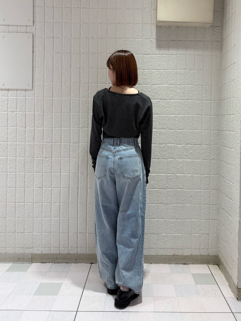 グレー系のキャミソール、ブルー系のデニムパンツを着用したレディースの春コーディネートの2枚目の写真