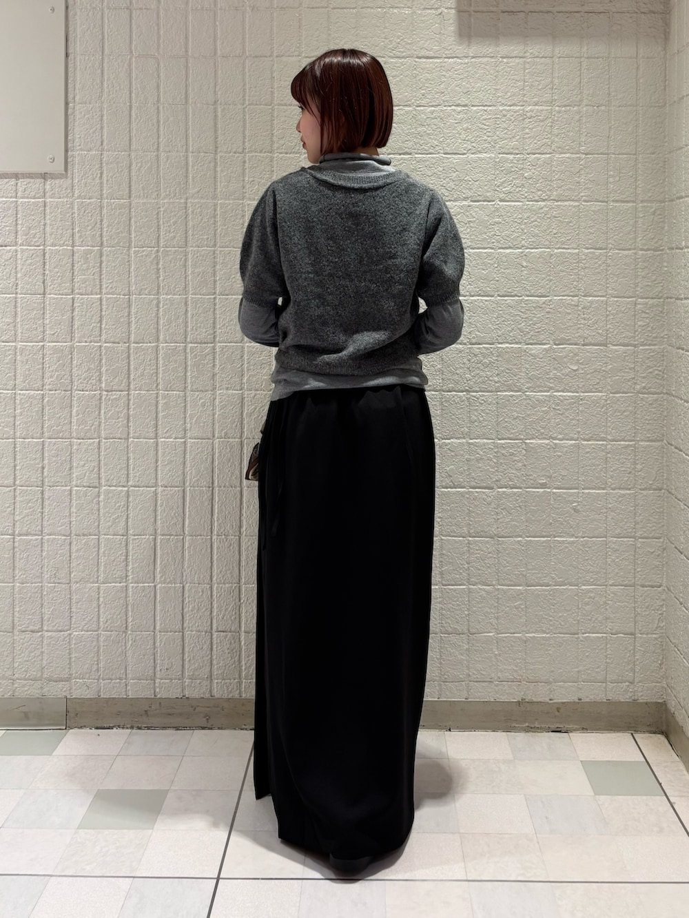 グレー系のカーディガン/ボレロ、ブラウン系のボストンバッグ、ブラック系のスカートを着用したレディースの秋コーディネートの3枚目の写真