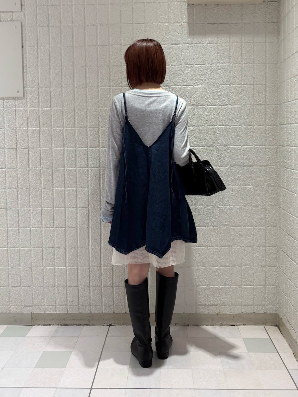 グレー系のTシャツ/カットソー、ブルー系のワンピース、ブラック系のボストンバッグを着用したレディースの冬コーディネートの3枚目の写真