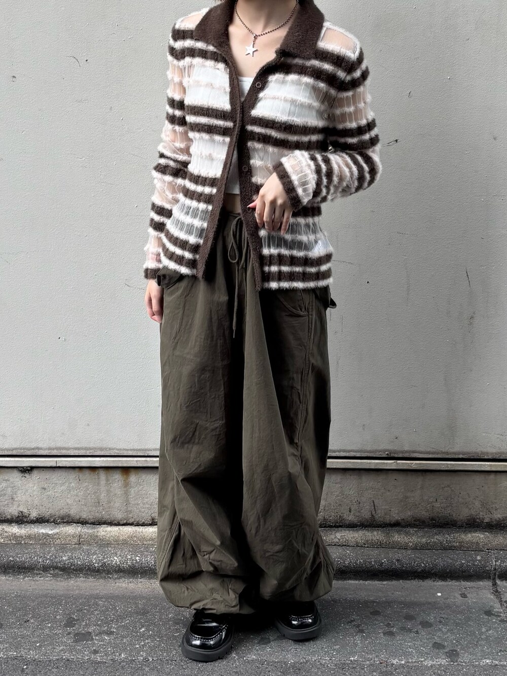 ブラウン系のニット/セーター、グリーン系のその他パンツを着用したレディースの秋コーディネートの2枚目の写真