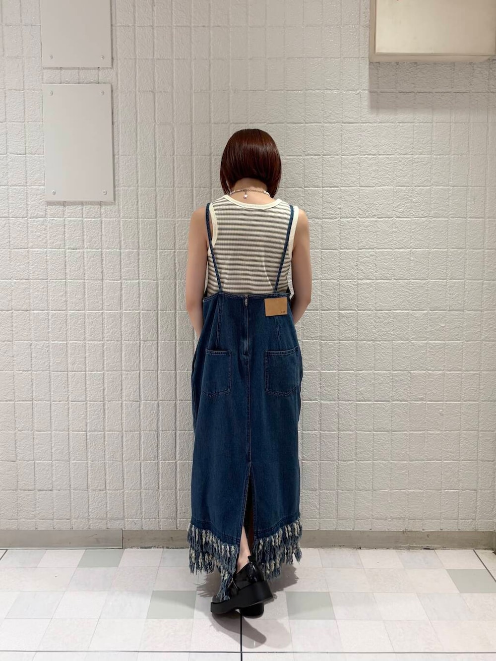 ホワイト系のタンクトップ、ブラック系のスニーカー、ブルー系のワンピースを着用したレディースの夏コーディネートの2枚目の写真