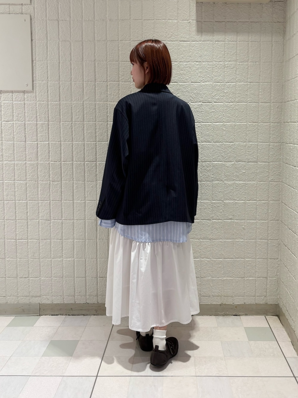 ブラウン系のTシャツ/カットソー、ブルー系のその他アウター、ホワイト系のスカートを着用したレディースの冬コーディネートの3枚目の写真